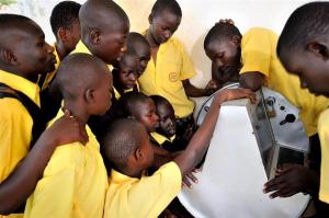 UGANDA, 2011. Young Ugandans gather around to use UNICEF’s unique innovation the solar-powered Digital Drum, at Bosco Youth Centre in Gulu, Uganda. The Digital Drum was this month chosen as one of Time Magazine’s Best Inventions of 2011. © UNICEF/UGDA2011-00099/YANNICK TYLLE